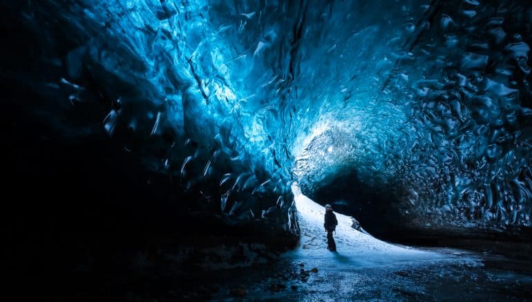 Un homme admirant une grotte de glace en Islande.
