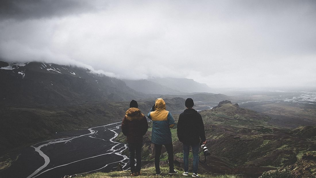 Trois personnes regardant des rivières dans les hautes terres islandaises.