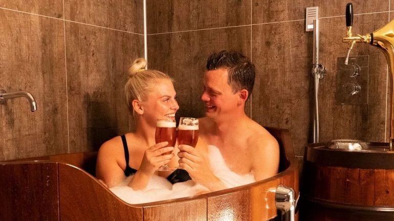 A couple in a tub filled with beer in North Iceland.