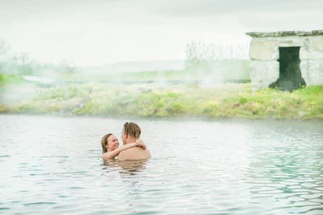 young couple relaxing in secret lagoon in South Iceland