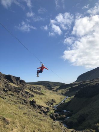 Une personne sur une tyrolienne passe au-dessus d'un canyon dans le sud de l'Islande