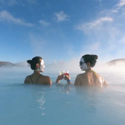Deux femmes avec des masques de silice prenant un verre au Blue Lagoon, Islande